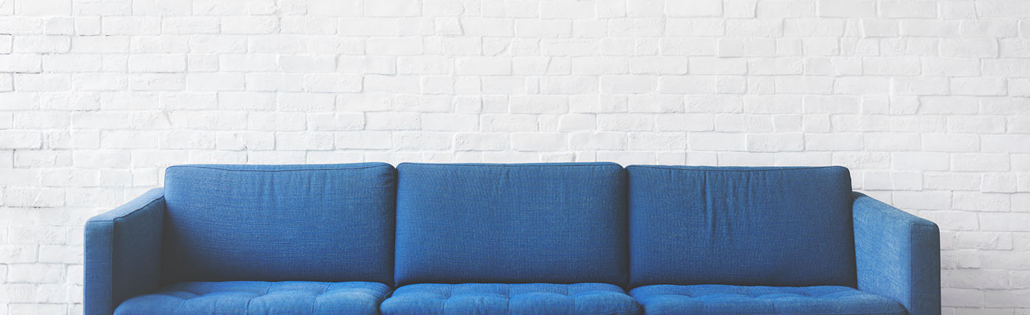 room with white walls and a blue sofa